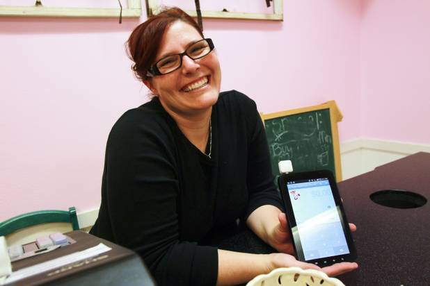 Angela Wallace shows the Square app she uses to process debit and credit card payments at her Lil’ Brown Sugar’s Cupcake Cafe in Henderson.