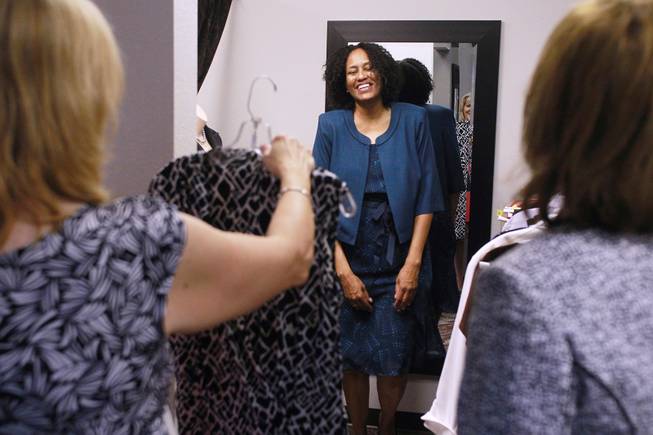 Sonji McTear smiles as Theresa Anderson, left, and Kelly Rissler find clothes for her to try on at Dress for Success Saturday, May 31, 2014.
