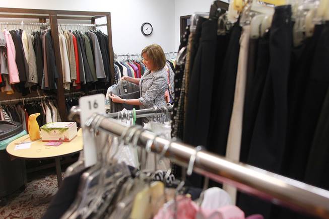 Manager Kelly Rissler looks through clothing for a client to try on at Dress for Success Saturday, May 31, 2014.