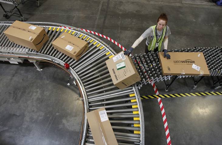 Katherine Braun sorts packages toward the right shipping area at an Amazon.com fulfillment center in Goodyear, Ariz. Amazon.com said Tuesday, Oct. 1, 2013, it is hiring 70,000 full-time seasonal workers around the U.S. to fill orders during the holiday season.