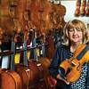 Violin Outlet owner Mara Lieberman displays some of her prized instruments at the Village Square Commercial Center, where her shop has supplied schools and performers for more than 30 years.
