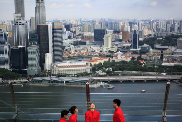 Cocktail waiters admire the financial skyline during their break on June 24, 2010, in Singapore. Singapore's second casino-resort's sky garden, which boasts a 160-meter infinity pool overlooking the city-state's financial skyline, opened Thursday, a massive $5.7 billion project by Las Vegas Sands Corp. that aims to make over the city-state as a Southeast Asian gambling and tourism magnet. 