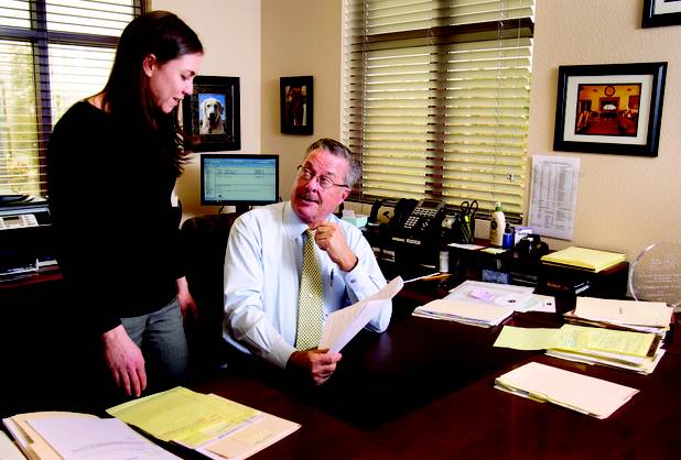 Attorney Al Marquis goes over documents with fellow attorney Kristin Gifford in the law offices of Marquis Aurbach Coffing.