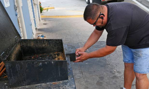 Clay Carrillo-Miranda unlocks a grease box in Fort Worth, Texas, on Thursday, April 23, 2014. Carrillo-Miranda drives a tanker truck that picks up used kitchen grease from area restaurants.