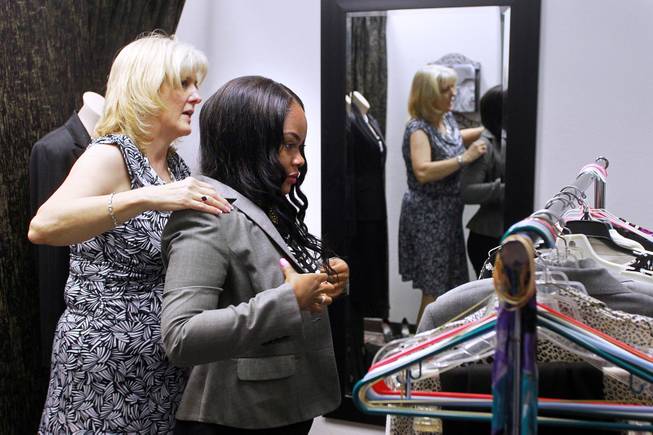Theresa Anderson helps Mercedes Matlock try on a jacket at Dress for Success Saturday, May 31, 2014.