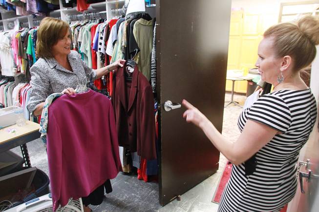 Volunteer Brenda Taylor, right, talks with manager Kelly Rissler as she picks out clothing for a client at Dress for Success Saturday, May 31, 2014.