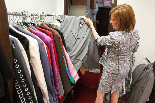 Manager Kelly Rissler looks through clothing for a client to try on at Dress for Success Saturday, May 31, 2014.