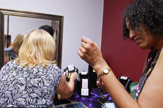 Sonji McTear tries on a watch as Theresa Anderson looks through other possible jewelry options at Dress for Success Saturday, May 31, 2014.